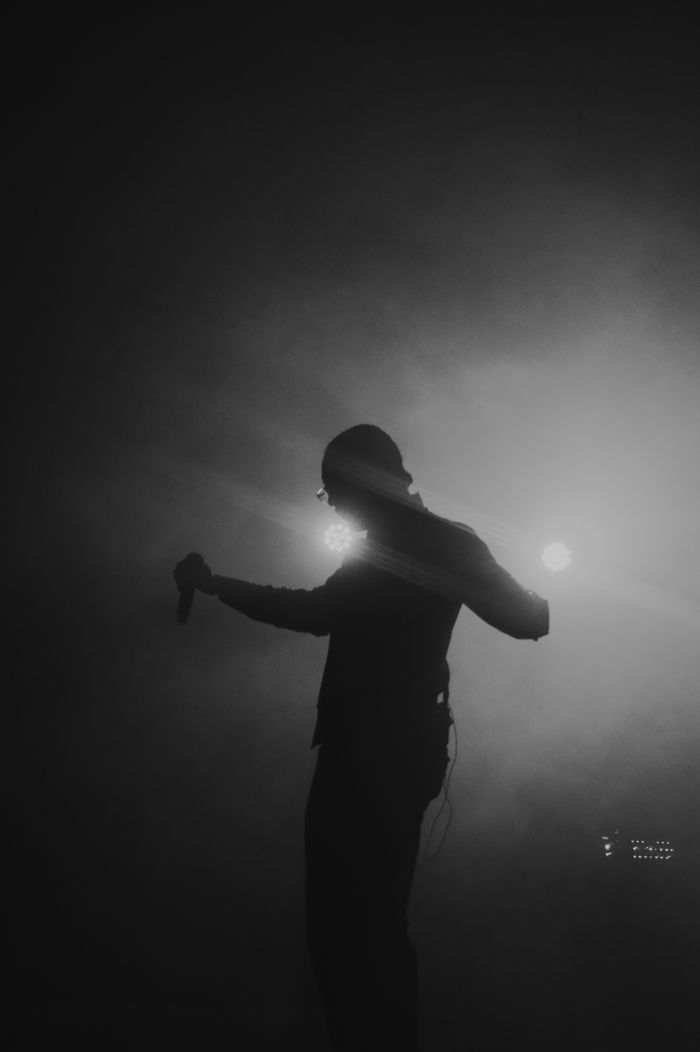 services-03 Silhouette of a performer with microphone in dramatic concert lighting.